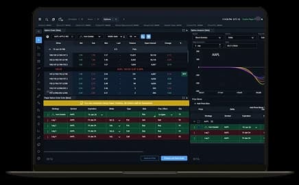 MacBook Pro displaying a futures trading platform interface with live market charts and trading tools on the screen.